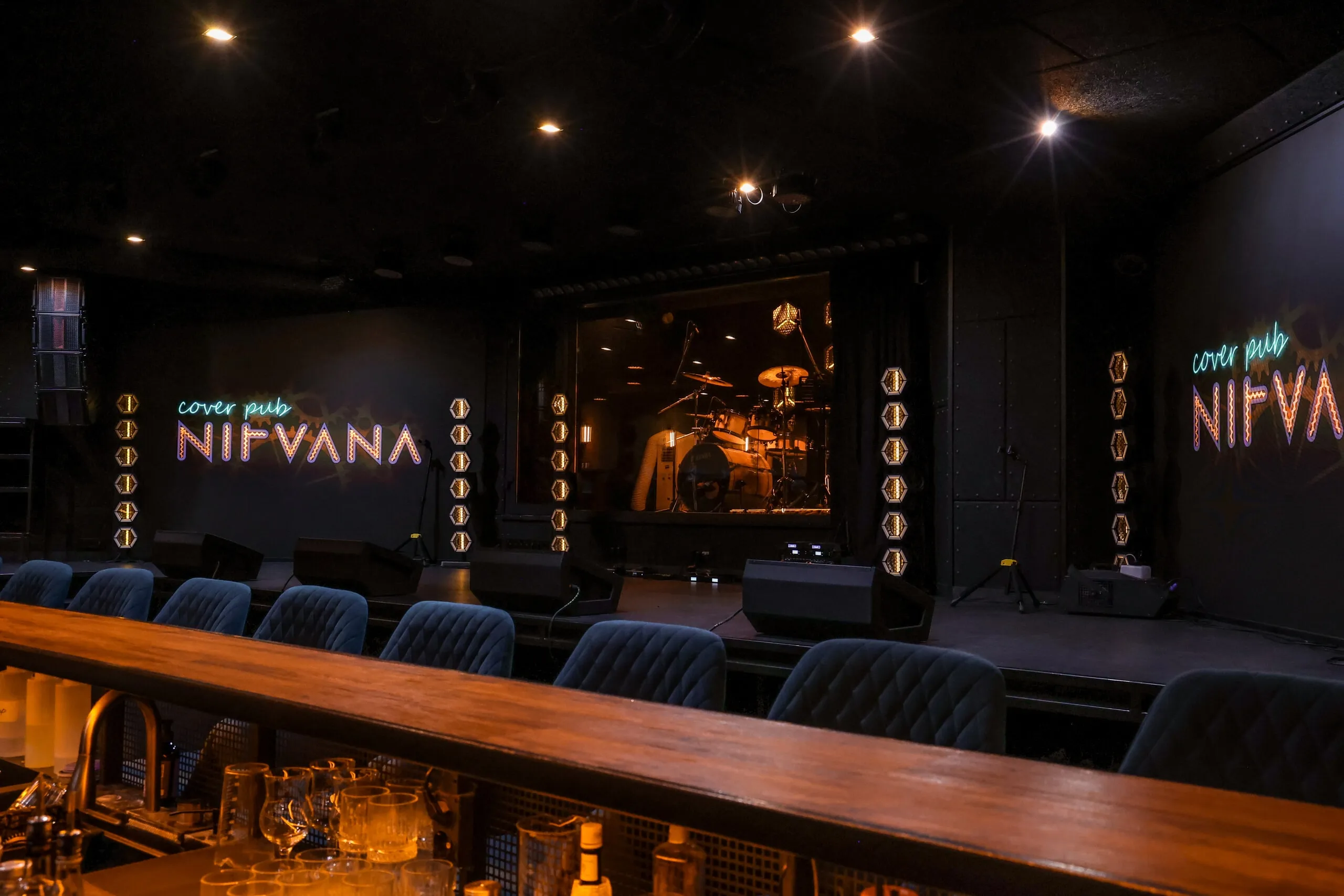 Зал паба Nirvana: сцена, неоновая вывеска и барная стойка